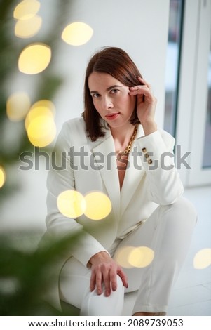Young European woman in trendy white suit, woman portrait.
