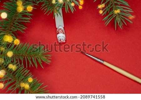 Christmas nail picture  Santa snowman and paint brush .Christmas flat lay frame with copy space on red bachground . beauty salon concept .