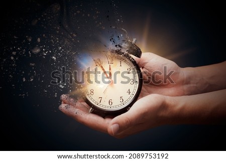 Concept of passing away, the clock breaks down into pieces. Hand holding analog clock with dispersion effect Royalty-Free Stock Photo #2089753192