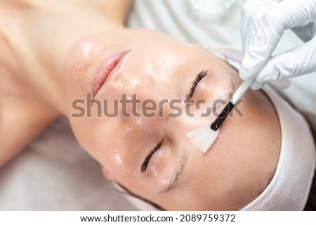 Close-up beautician doctor hand making anti-age procedure apply peeling acid young attractive female client at beauty clinic. Cosmetologist specialist doing skincare treatment. Health care therapy Royalty-Free Stock Photo #2089759372