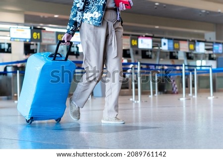 people wearing medical masks walking with luggage bags suitcases at the airport travel concept. High quality photo Royalty-Free Stock Photo #2089761142
