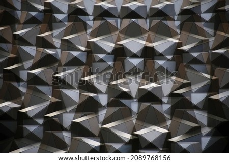 Double exposure photo of triangular elements of a wall or ceiling. Industrial structure. Modern building interior. Abstract architecture background. Irregular geometric pattern of trianlges.