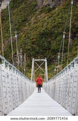 Hiker walks on a swing bridge