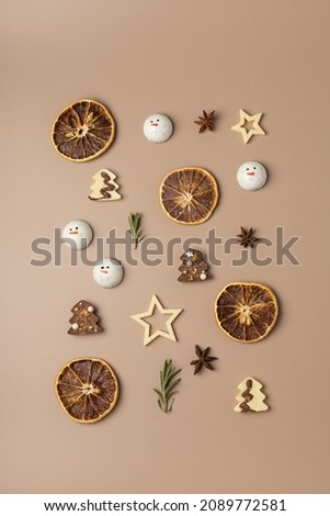 Christmas decor of dried oranges, stars, chocolate, rosemary on a beige background