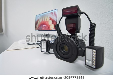 Camera and macro lens with  flash equipment too be used by dentist for taking a pictures of a patient's teeth. Selective focus.