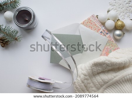 Christmas, winter  composition.Envelope , notebook, candle,fir tree branches, scarf,  balls on white background. Christmas, winter, new year concept. Flat lay, top view, copy space