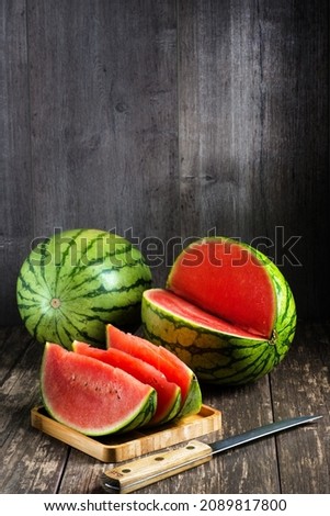 juicy slices of fresh cut watermelon on a wooden table. Space for an inscription on a gray background.