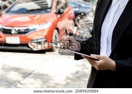 A person holding a file, a female employee of a car rental company is about to deliver the car to a customer who has signed a rental contract and paid the deposit. Car rental concept. Royalty-Free Stock Photo #2089820884