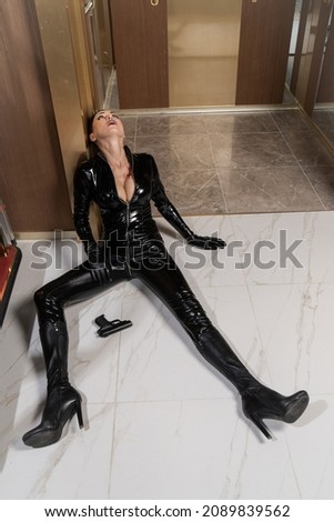 Hit woman. Woman in a latex suit killed in gunfire shot in the chest

 Royalty-Free Stock Photo #2089839562