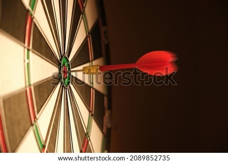 Dartboard with darts stuck right in center of the target