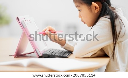 A girl studying on a tablet computer. Royalty-Free Stock Photo #2089855114