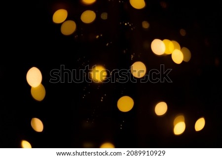 black background with golden glittering lights bokeh. abstract defocused pattern. Christmas concept