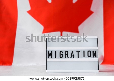 The National Flag of Canada. Lightbox with text MIGRATION Canadian Flag or the Maple Leaf. Patriotism. International relations concept. Independence day. Immigration