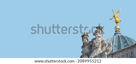 Very old roof statute of a golden angel in historical downtown of Dresden, Germany, details, at blue sky solid background with copy space