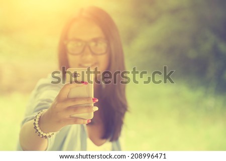 Vintage photo of woman taking a selfie with smart phone