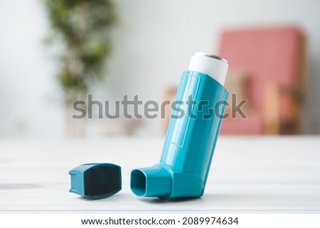 Modern inhaler on table at home, closeup