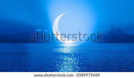 Ramadan concept - Crescent moon over the tropical sea at night "Elements of this image furnished by NASA" Royalty-Free Stock Photo #2089979689