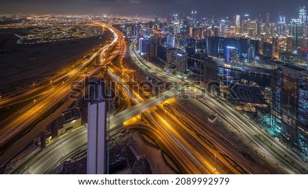 Panorama showing skyline of Dubai with business bay and downtown district night timelapse. Aerial view of many modern skyscrapers and busy traffic on al khail road. United Arab Emirates.