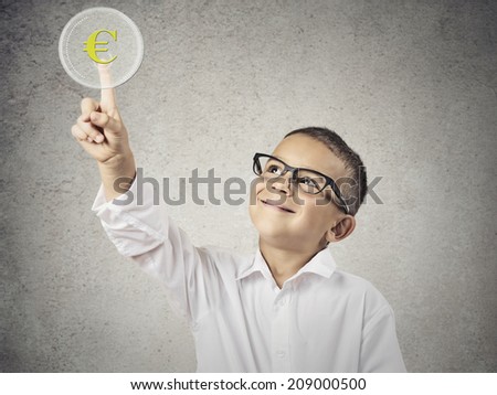 Closeup portrait happy, smiling child touching yellow euro currency sign button on touchscreen display isolated grey wall background. Positive face expression, emotion,  perception. Exchange concept