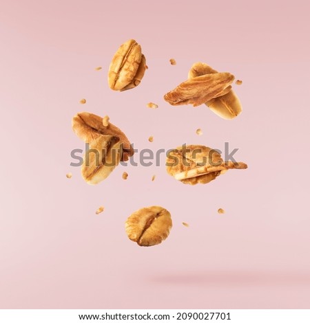 Fresh Granola flakes falling in the air on pink background. Food zero gravity conception. High resolution image Royalty-Free Stock Photo #2090027701