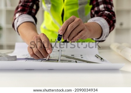 Architects, engineers, designers, use compasses to draw on house designs. He is editing the designs that have been created on the program on the computer. Interior design and decoration ideas.
