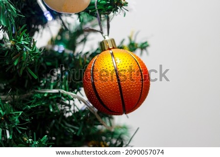 Close up of decorations on a Christmas tree with a basketball ball. Selective focus.