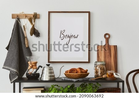 Stylish and cozy kitchen interior composition with mock up poster frame, black console, kitchen textile, teapot, plants and retro inspired accessories. Template. Autumn vibes.
