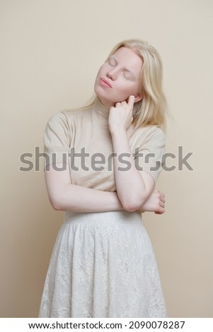 Cute albino girl  on a beige background.