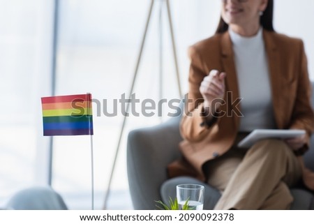 small lgbt flag near cropped psychologist with digital tablet on blurred background Royalty-Free Stock Photo #2090092378