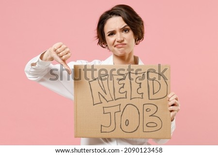 Young sad employee business secretary woman corporate lawyer in classic formal white shirt work in office hold cardboard sign card need job show thumb down gesture isolated on pastel pink background Royalty-Free Stock Photo #2090123458