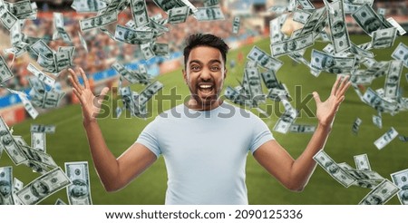 online betting, gambling and sport concept - happy man with raised hands and money rain over football field background