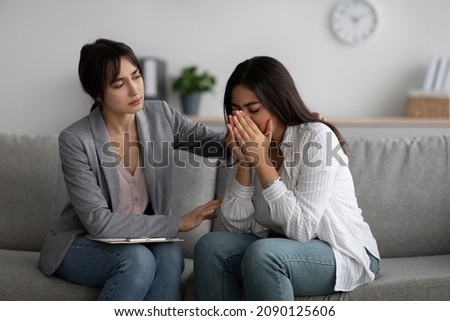 Depression, nervous breakdown concept. Compassionate psychologist providing help to unhappy arab lady during session at mental health clinic, assisting female patient Royalty-Free Stock Photo #2090125606