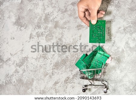 Electronic printed circuit boards in a shopping cart on a light background. Recycling of electronic waste and repair of broken household appliances. The concept of eco-friendly recycling of electronic