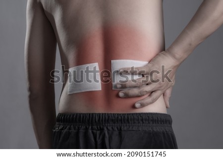 Medicated pain relief patch with man pain Lower Back,office syndrome,Health problems from overworked concept. Royalty-Free Stock Photo #2090151745