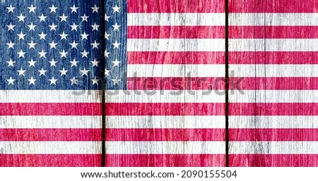 Grunge pattern of USA national flag isolated on weathered wooden fence board. Abstract US politics history culture concept background