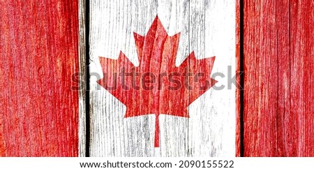 Grunge pattern of Canada national flag isolated on weathered wooden fence board. Abstract Canadian politics history culture concept background