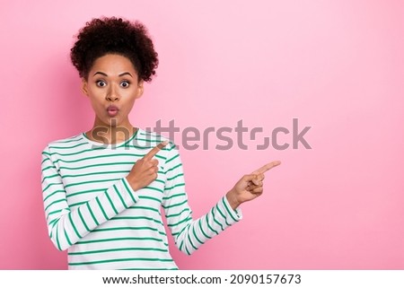 Photo of impressed wavy hairstyle millennial lady index empty space wear striped shirt isolated on pink color background