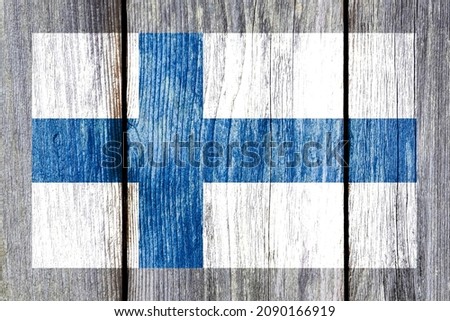 Grunge pattern of Finland national flag isolated on weathered wooden fence board. Abstract Finnish politics history culture concept background