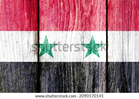 Grunge pattern of Syria national flag isolated on weathered wooden fence board. Abstract Syrian politics history culture concept background
