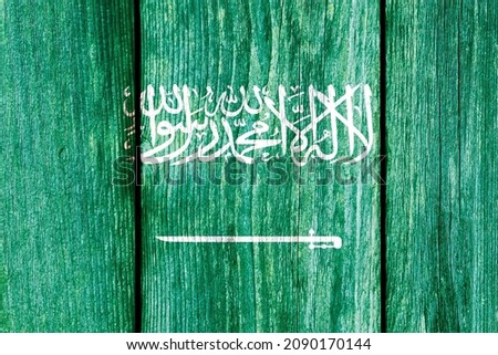 Grunge pattern of Saudi Arabia national flag isolated on weathered wooden fence board. Abstract Middle East Saudi Arabia politics history culture concept background