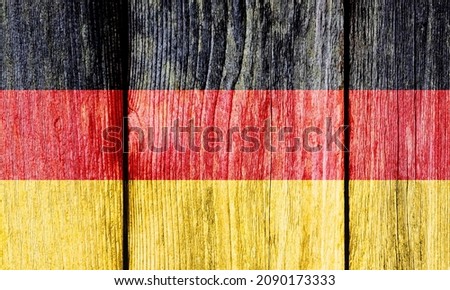 Grunge pattern of Germany national flag isolated on weathered wooden fence board. Abstract German politics history culture concept background