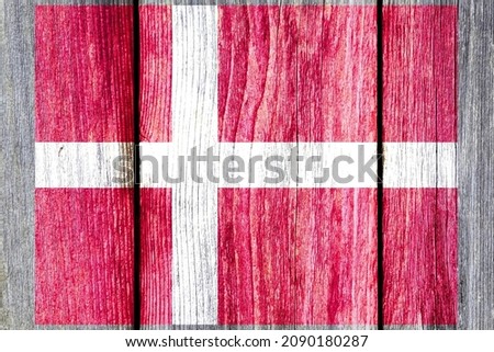 Grunge pattern of Denmark national flag isolated on weathered wooden fence board. Abstract Denmark politics history culture concept background
