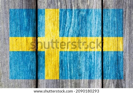 Grunge pattern of Sweden national flag isolated on weathered wooden fence board. Abstract Swedish politics history culture concept background