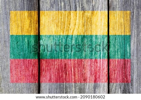 Grunge pattern of Lithuania national flag isolated on weathered wooden fence board. Abstract Lithuania politics history culture concept background