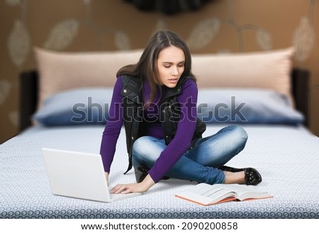 Young happy smiling female student watching an online class on laptop computer