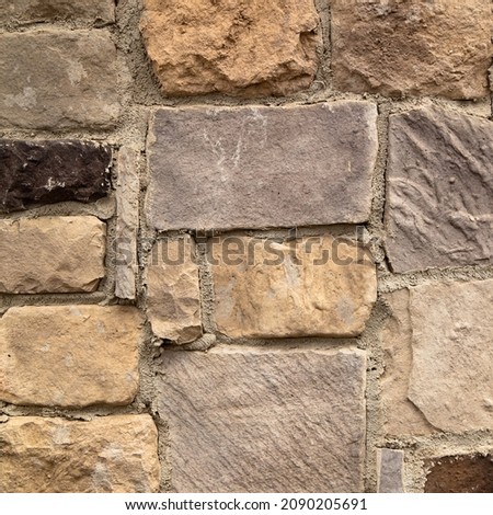 Sturdy yellow and beige cut stone wall, good for backgrounds, seamless lined up