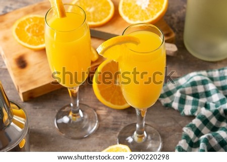Orange mimosa cocktail on wooden table Royalty-Free Stock Photo #2090220298