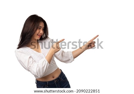 Happy Asian woman smiling with thumbs up pointing at empty space on white background