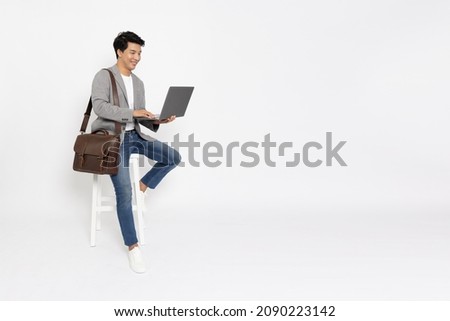 Young Asian business man using laptop computer and sitting on white chair isolated on white background, Full length composition