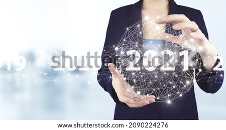Concept Start New Year 2021. Two hand holding virtual holographic 2021 icon with light blurred background. Concept for vision 2021. Businessman welcome year 2021